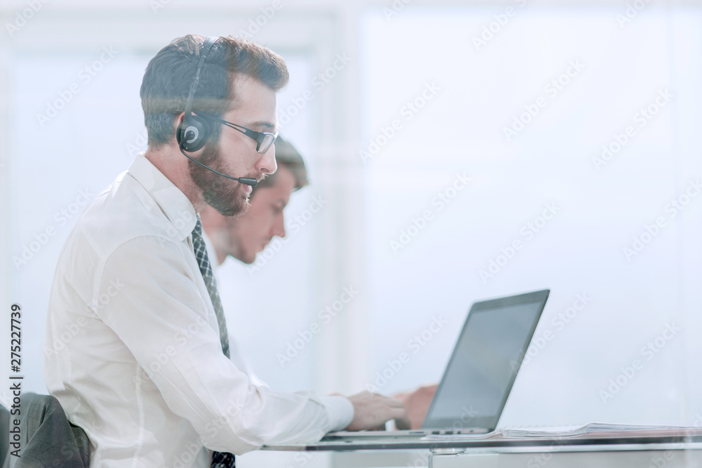 business man in headphones sitting at his Desk business man in headphones sitting at his Desk