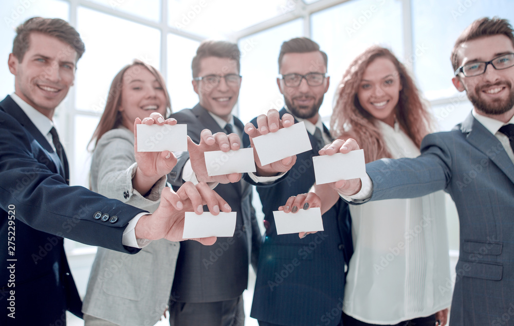 Obraz premium smiling business team showing their business cards.