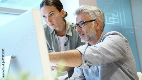 Coworkers discussing business in modern office