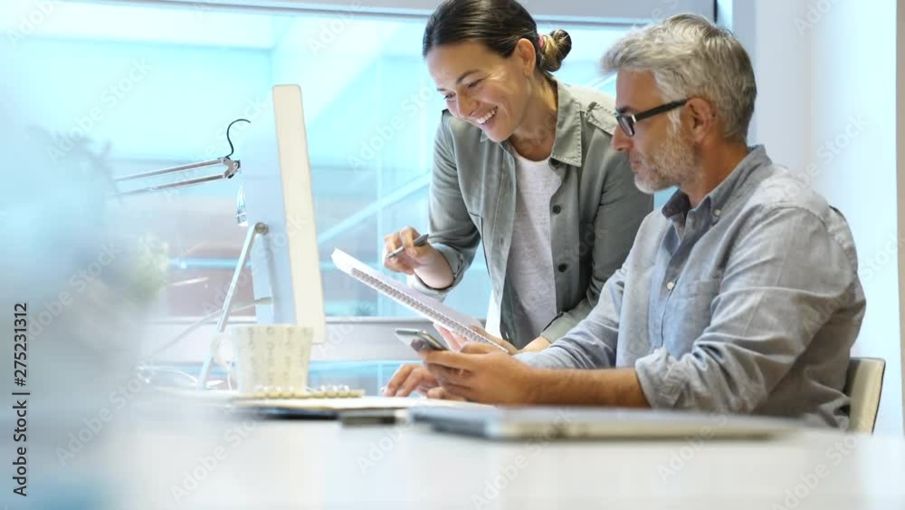Coworkers discussing business in modern office