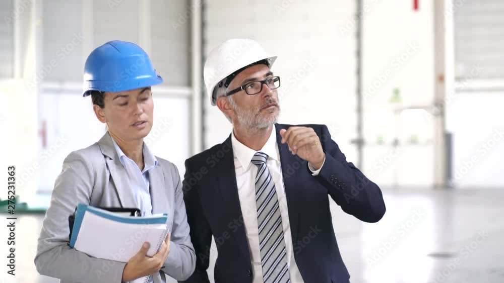 Architects visiting large warehouse together Architects visiting large warehouse together