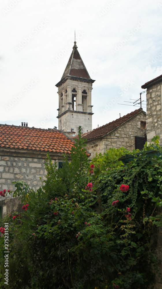 Obraz premium Stone house in the street of old town, beautiful architecture, Tower of the Church of Our Lady, Trogir, Dalmatia, Croatia