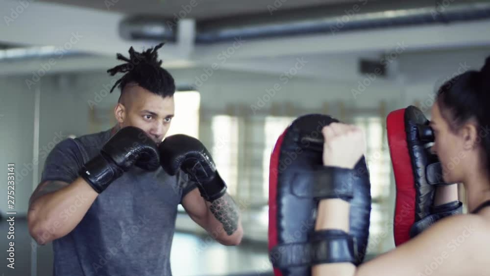 Young couple in gym with boxing gloves doing exercise indoors. Young couple in gym with boxing gloves doing exercise indoors.