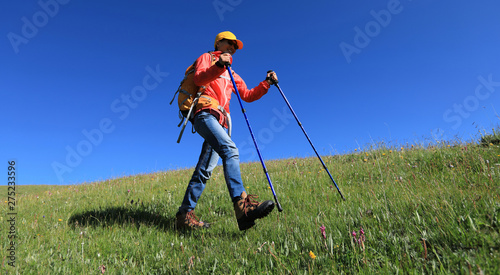 Backpacking woman hiking in the high altitude grassland mountains
