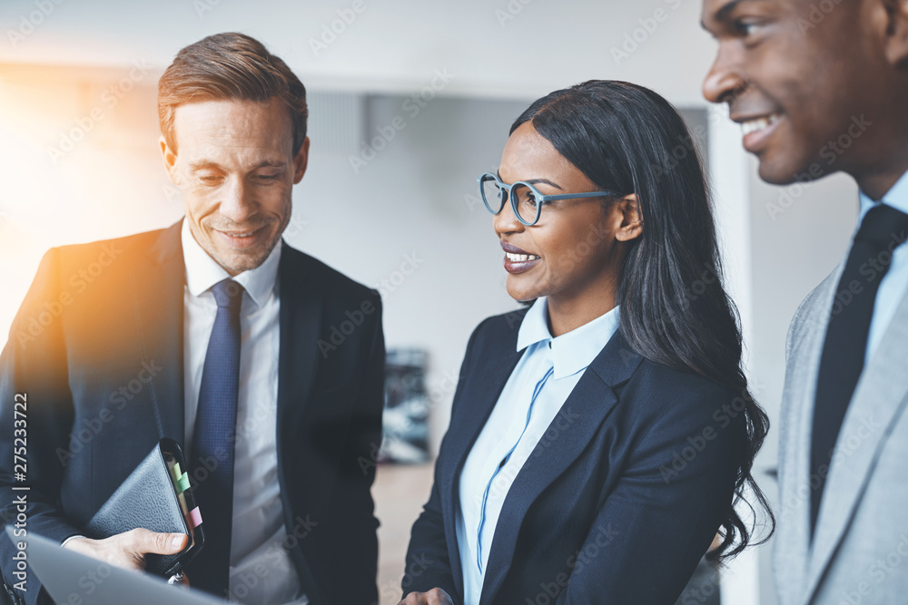 Smiling African American businesswoman talking with colleagues o Smiling African American businesswoman talking with colleagues o
