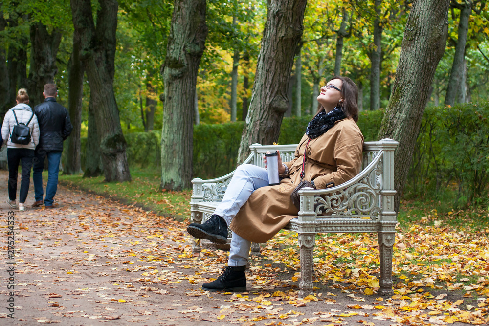 Fototapeta premium Woman relaxes sitting on a bench
