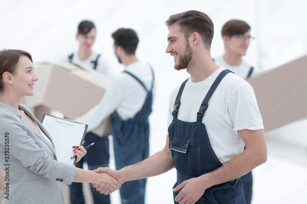 Manager with clipboard shaking hands with movers. Manager with clipboard shaking hands with movers.