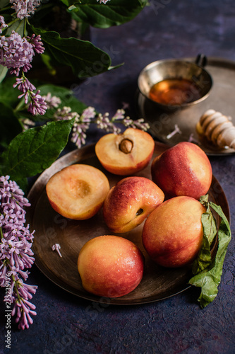 still life with peach and flowers on wooden table