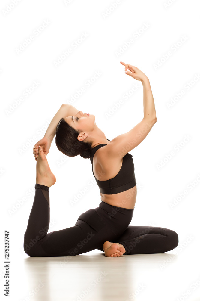Young yoga woman doing mermaid yoga pose on white background