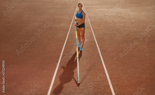 Photos Professional female pole vaulter training at the stadium in sunny day