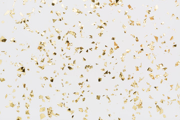 Golden confetti on white background. Festive, party or holiday glitter backdrop. Flat-lay, top view.