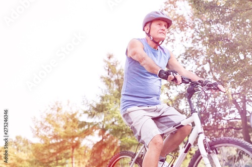 Senior male athlete riding bicycle in park