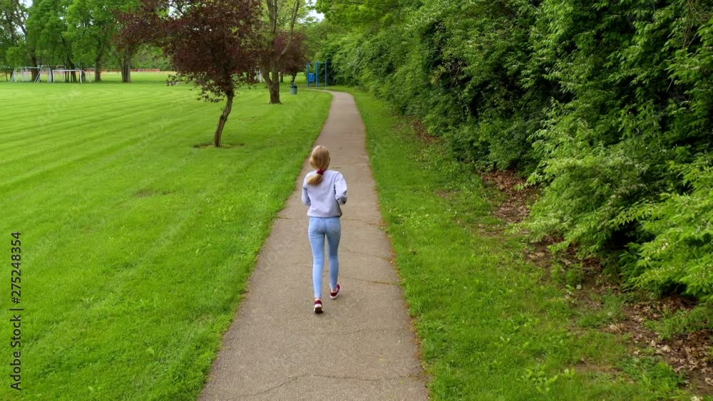 Girl runs down path in park to escape tracking shot 4k Girl runs down path in park to escape tracking shot 4k