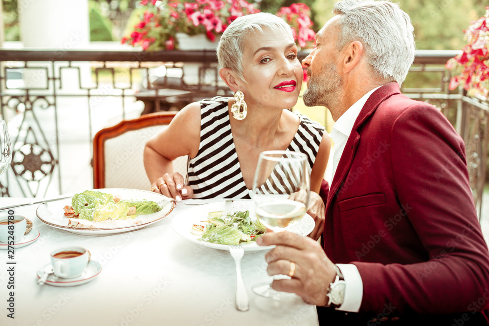 Husband kissing his wife while having romantic dinner Husband kissing his wife while having romantic dinner