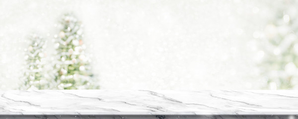 Empty white marble table top with abstract warm living room decor with christmas tree string light blur background with snow,Holiday backdrop,Mock up banner for display of advertise product.