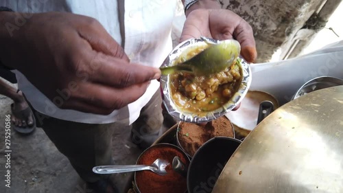 Street food- Chole Kulche- popular fast meal with dry chickpeas spicy masala mixture with maida based bread Kulcha in India, Pakistan and Bangladesh.  4k slow-motion close-up stabilized handheld  photo