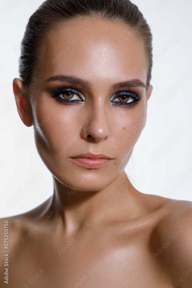 Portrait of a sexy woman with wet black hair. Professional smoky makeup. Long hair combed up. Look into the camera, brown eyes, close-up on white isolated background Portrait of a sexy woman with wet black hair. Professional smoky makeup. Long hair combed up. Look into the camera, brown eyes, close-up on white isolated background