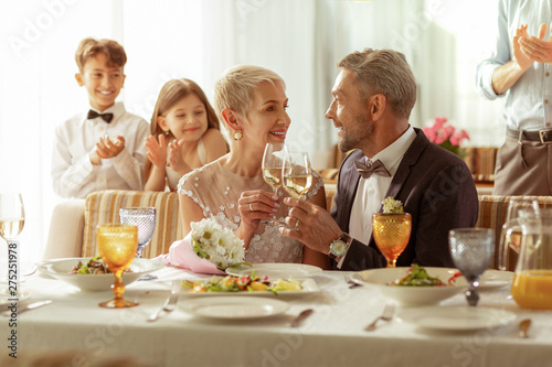 Aged bridge and groom clanging their glasses with champagne