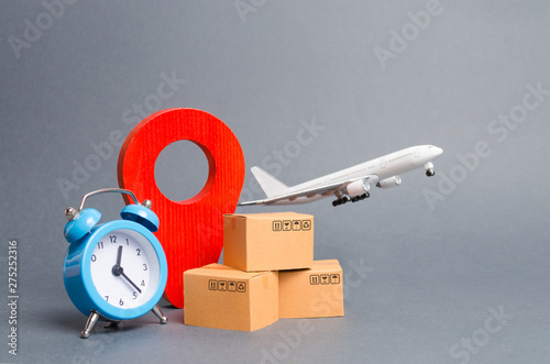 Airplane and stack of cardboard boxes, red position pin and blue alarm clock. concept of air cargo and parcels, airmail. Fast delivery of goods and products. Cargo aircraft. Logistics, connection photo