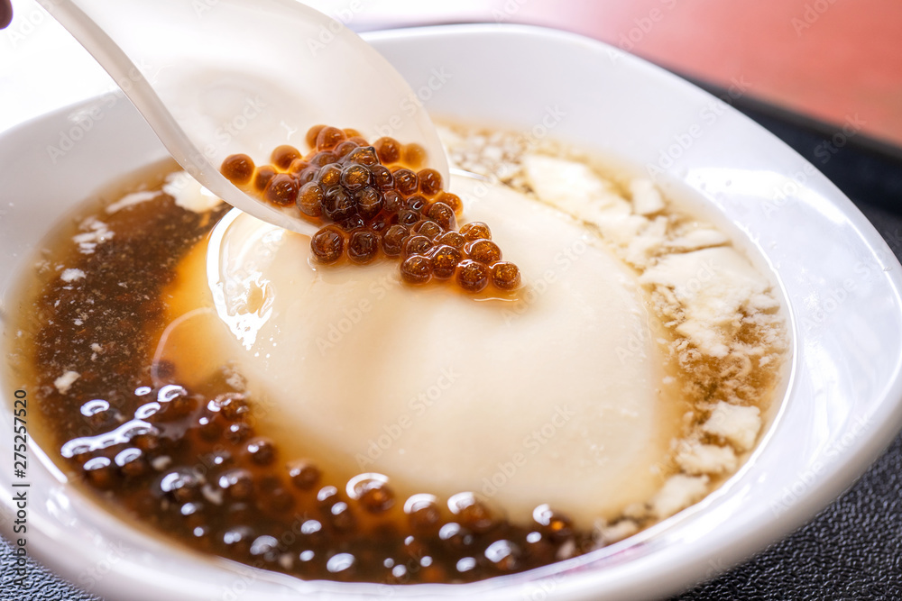 Popular Taiwan gourmet - Dessert of tapioca pearl ball (bubble) mixed bean curd tofu pudding (douhua, dou hua) in white bowl, close up, lifestyle Popular Taiwan gourmet - Dessert of tapioca pearl ball (bubble) mixed bean curd tofu pudding (douhua, dou hua) in white bowl, close up, lifestyle