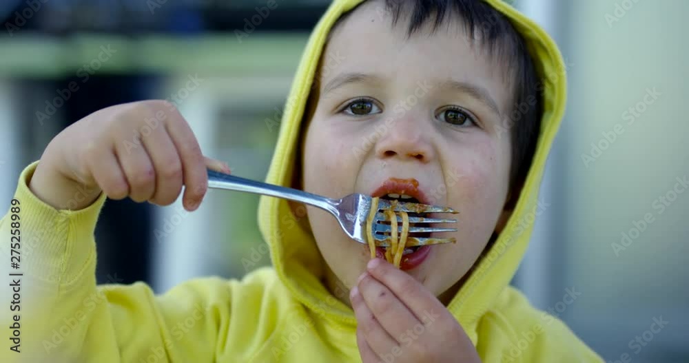 Toddler boy eating pasta off of fork and hands - close up - slow motion Toddler boy eating pasta off of fork and hands - close up - slow motion
