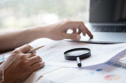 man looking through a magnifying glass to documents. Business assessment and audit. Magnifying glass on a financial report. Close-up Of Checking Bills With Magnifying Glass.Concept of search.