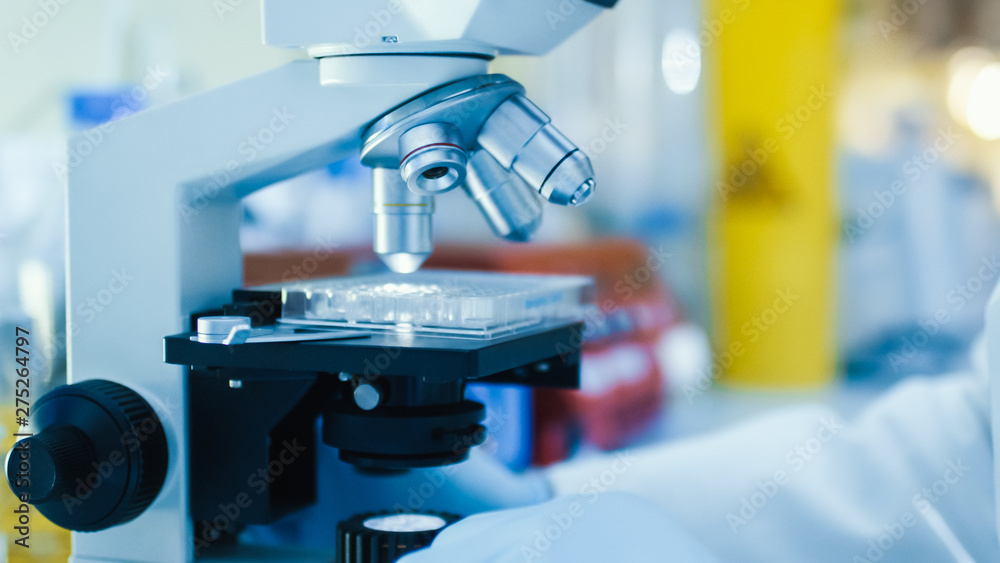 Close-up Shot of a Scientific Microscope with Test Tubes in a High-Tech Genetic Research Laboratory. Close-up Shot of a Scientific Microscope with Test Tubes in a High-Tech Genetic Research Laboratory.