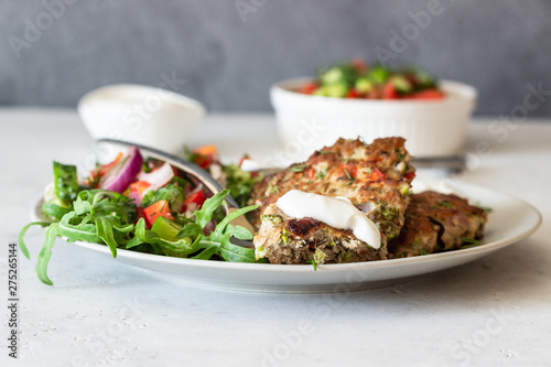 Chicken or turkey cutlets with vegetables and sauce on a plate. Delicious cutlets with salad. Selective focus.