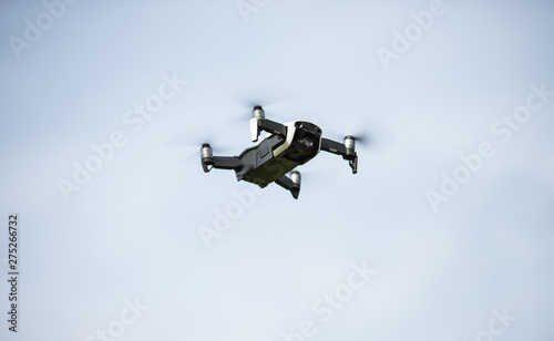 Fototapeta Naklejka Na Ścianę i Meble -  Black drone with propellers flies into the sky and photographs landscapes