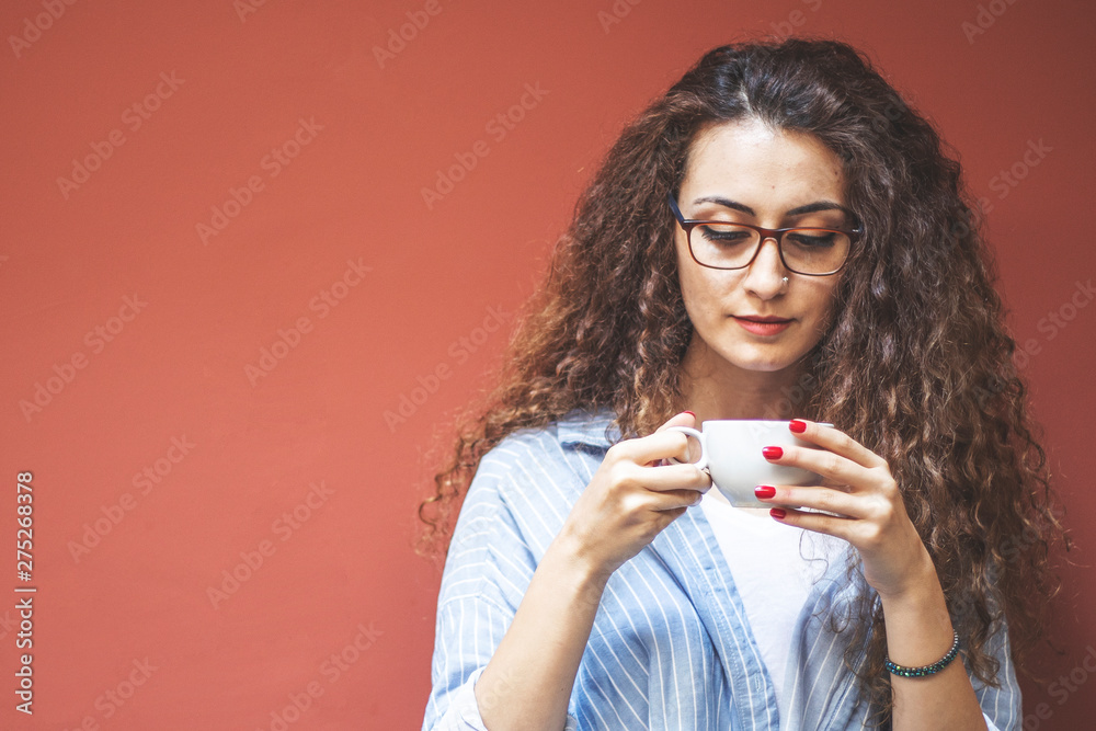 Beautiful woman drinking coffee at cafe. Portrait of young woman in a cafeteria drinking hot cappuccino. Pretty woman with cup of coffee. Beautiful woman drinking coffee at cafe. Portrait of young woman in a cafeteria drinking hot cappuccino. Pretty woman with cup of coffee.