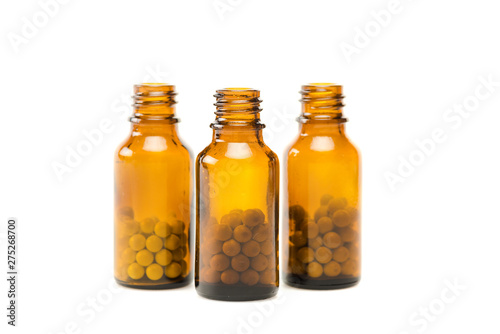 round pills in small glass orange bottles isolated on white