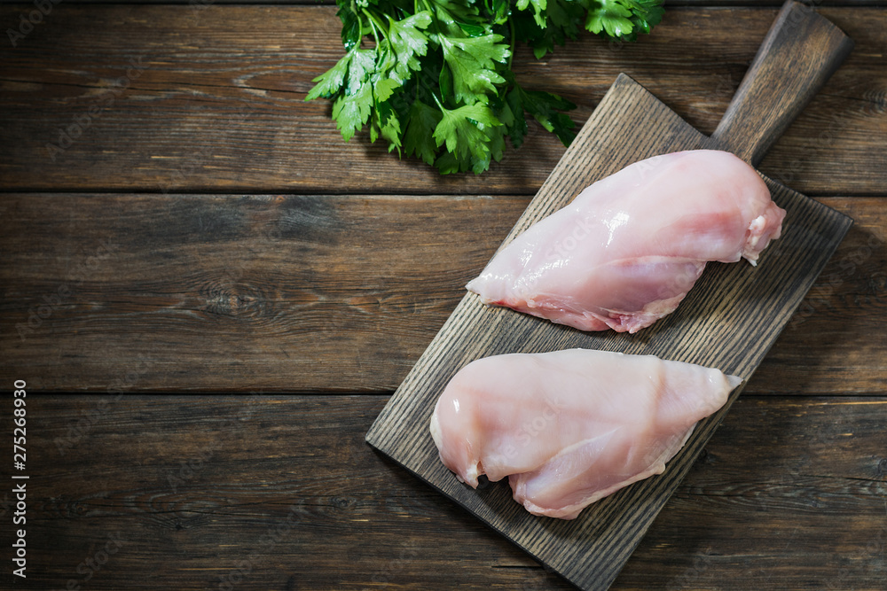 Chicken breast fillet on wooden table. Rustic style