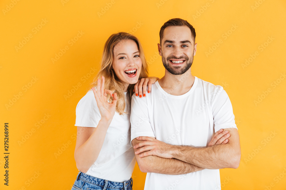 Excited cheerful young couple standing isolated Excited cheerful young couple standing isolated