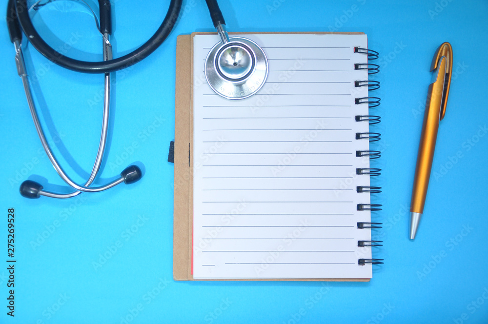 Blank notebook and medical stethoscope top view. Doctor’s work table concept. Health care concept Blank notebook and medical stethoscope top view. Doctor’s work table concept. Health care concept