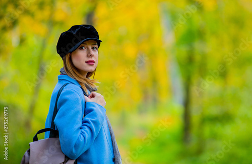 girl in coat and hat in a park.