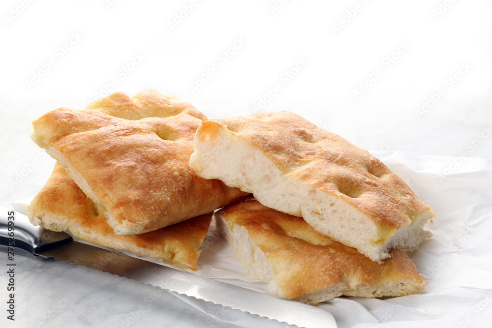 slices of traditional italian focaccia and a knife rest on a marble table with copy space for your text slices of traditional italian focaccia and a knife rest on a marble table with copy space for your text