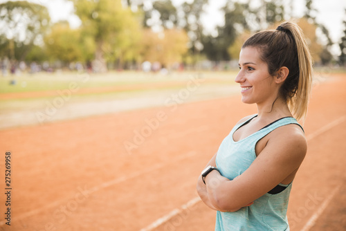 Sporty woman stretching on stadium track