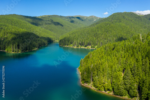 Mountain forest lake landscape. Aerial view. View on the turquoise color lake between mountain forest. Over beautiful turquoise mountain lake and green forest. National park. Green pine and fir trees