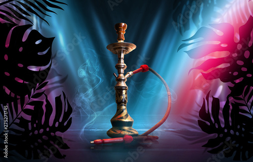 Smoking hookah on a dark abstract background, neon light. Silhouettes of tropical palm leaves in the foreground.