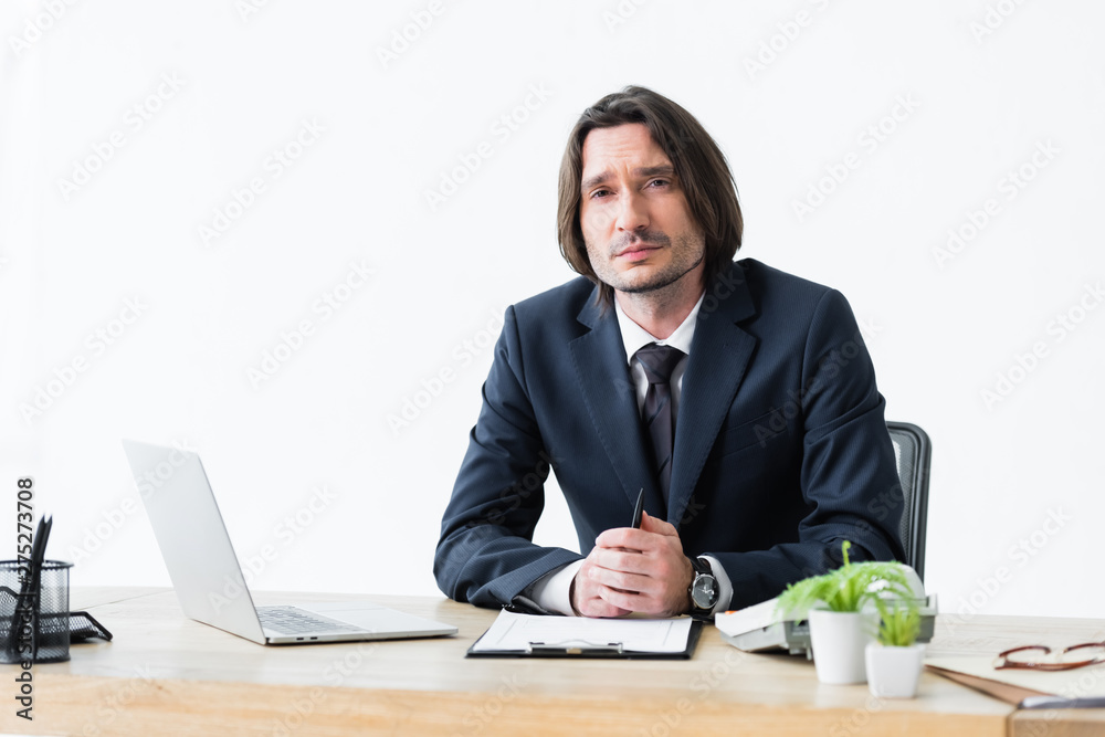 serious businessman sitting in office and looking at camera serious businessman sitting in office and looking at camera