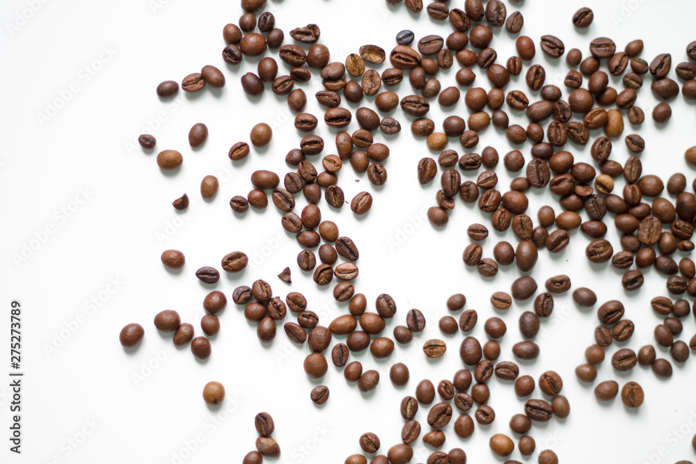 brown coffee grains on a white isolated background with space top view