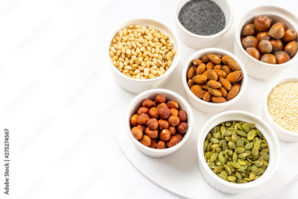 Various Nuts and Seeds on White Background in the Bowls with Free Space for Text Various Nuts and Seeds on White Background in the Bowls with Free Space for Text