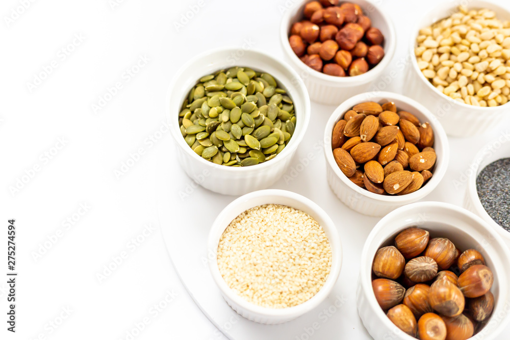 Various Nuts and Seeds on White Background in the Bowls with Free Space for Text Various Nuts and Seeds on White Background in the Bowls with Free Space for Text