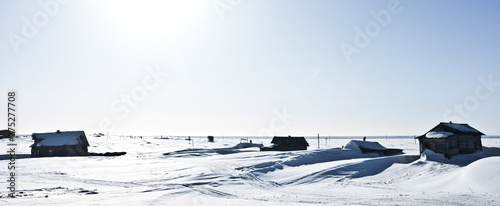 Nearly abandoned fishers settlement in the middle of snow desert on Kola Peninsula; several houses completely covered with snow