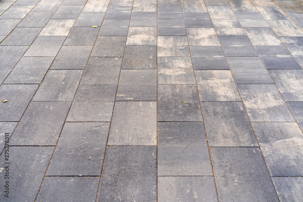 paving concrete tiles from which the pavement is laid. Background, abstraction, gray.