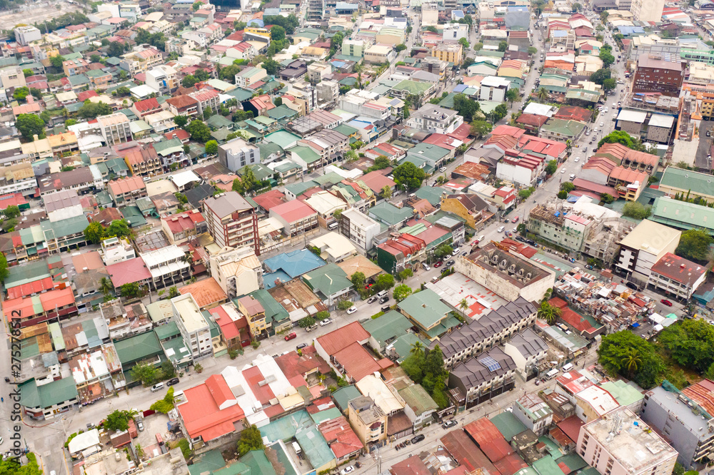 Residential areas and streets of Manila, Philippines, top view. Roofs of houses and roads. Philippine capital.