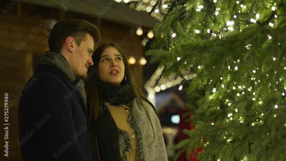 Couple admiring a Christmas tree Couple admiring a Christmas tree