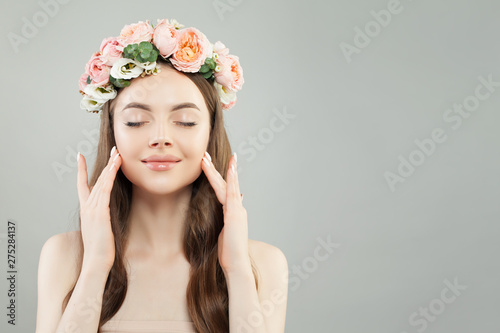 Spa beauty model woman with healthy skin, curly hair and flowers. Skincare and facial treatment concept