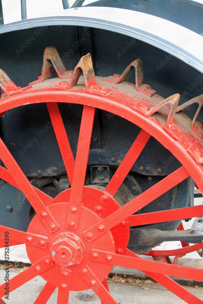 Antique tractor wheel with red spokes abstract steampunk machinery