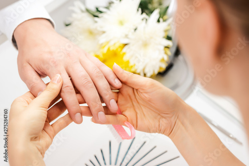Slika na platnu Pedicurist looking at fingernails of man prior to manicure
